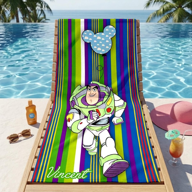 Puede incluir: Una toalla de playa a rayas verticales en verde, morado, azul y rojo. La toalla presenta una imagen de dibujos animados de Buzz Lightyear y una cabeza de Mickey Mouse con un patr&oacute;n de nubes. El nombre "Vincent" est&aacute; impreso en la toalla.