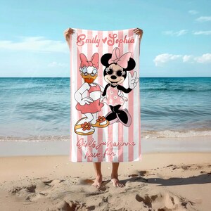 May include: A pink and white striped beach towel featuring Daisy Duck and Minnie Mouse. The towel has the text "Emily Sophia" and "Girls just wanna have fun". The characters are wearing sunglasses and dresses.