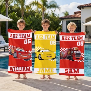 May include: Three beach towels with Cars movie characters. The towels are red and yellow, with the text "AKZ TEAM 05" and the names William, Jame, and Sam. Each towel features a different car graphic.
