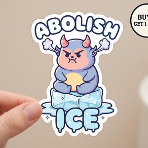 May include: A sticker featuring a cartoon character with horns and a grumpy expression, sitting on a block of ice. The sticker reads "ABOLISH ICE" in blue and white bubble letters. A circular graphic reads "BUY 5 GET 1 FREE".