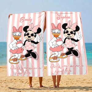 May include: Two beach towels with pink and white stripes, each featuring a cartoon of Minnie Mouse and Daisy Duck. The towels have the names "Emily" and "Sophia" printed on them, along with the phrase "Girls just wanna have fun."