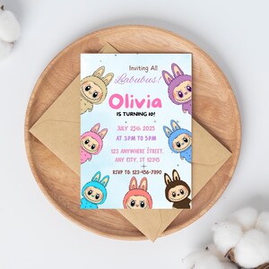 May include: A birthday invitation featuring the text "Inviting All Labubus! Olivia is turning 10!" surrounded by cartoon characters in various colors. The invitation is on a light blue background with event details and RSVP information.