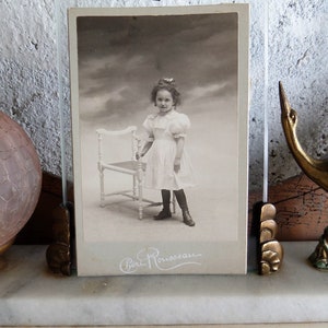 Um armário de fotos em papelão, querida jovem com vestido de domingo, da fotografia francesa de 1890.