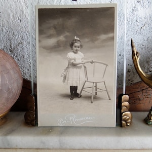 Um armário de fotos em papelão, querida jovem com vestido de domingo, da fotografia francesa de 1890.
