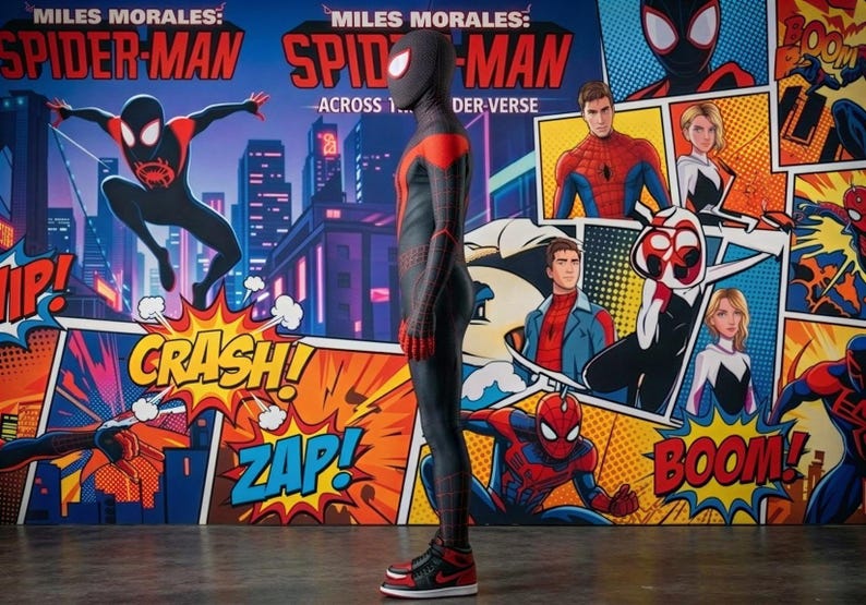 May include: A full-body Spider-Man costume in black and red, standing in front of a comic book-style backdrop. The backdrop features the words "Miles Morales: Spider-Man Across the Spider-Verse" and comic book sound effects like "Crash!" and "Zap!"