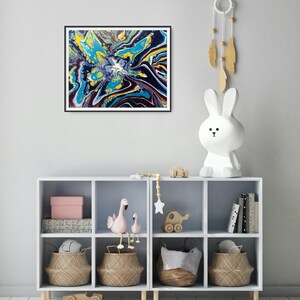 K&ouml;nnte beinhalten: Abstrakter Kunstdruck in einem schwarzen Rahmen. Das Kunstwerk zeigt eine lebendige Mischung aus Farben, darunter Gelb, T&uuml;rkis und Marineblau, die ein dynamisches und flie&szlig;endes Design erzeugt. Das Gem&auml;lde wird &uuml;ber einem wei&szlig;en Aufbewahrungsm&ouml;bel mit dekorativen Gegenst&auml;nden ausgestellt.