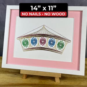 May include: Framed artwork featuring a string art design of a geometric shape with colorful starburst patterns. The artwork is framed in a white frame with a pink mat. The dimensions are 14" x 11". The text "NO NAILS • NO WOOD" is visible.