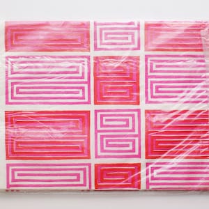 May include: Pink and red geometric pattern wrapping paper with a white background. The pattern is made up of repeating squares with a series of concentric squares inside.