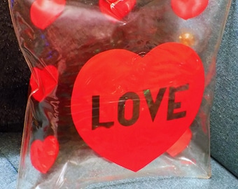 Almohada inflable "LOVE" de Contessa, de la década de 1970, con corazones rojos, transparente, letras y gráficos rojos, 30 x 30 x 10 cm.