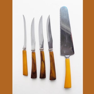 May include: Set of five vintage knives with brown and yellow plastic handles. The set includes four butter knives and one cake server.