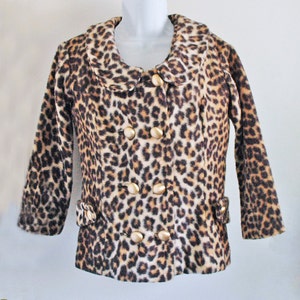 May include: A brown and white leopard print jacket with a large collar and gold buttons.