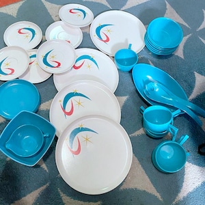 Op de afbeelding: Een set vintage blauw en wit servies met een stervormig ontwerp. De set bevat borden, kommen en een serveerschaal.