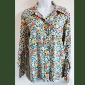Puede incluir: Una camisa de manga larga con botones y estampado floral en tonos verdes, rojos, amarillos y blancos.