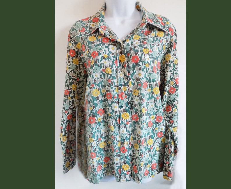 Puede incluir: Una camisa de manga larga con botones y estampado floral en tonos verdes, rojos, amarillos y blancos.