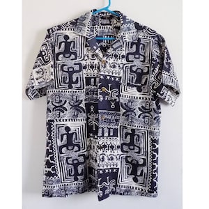 Pu&ograve; includere: Una camicia a maniche corte con bottoni, con un motivo geometrico bianco e nero.