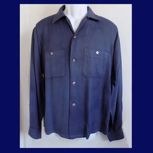 Op de afbeelding: Een overhemd met lange mouwen en knoopsluiting in een effen donkerblauwe kleur. Het overhemd heeft een klassieke kraag, een knoopsluiting aan de voorzijde en twee borstzakken met knoopsluiting. De stof heeft een gladde, matte afwerking.
