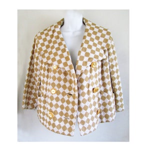 May include: A brown and white checkered cropped jacket with gold buttons. The jacket has a wide collar and a double breasted closure.