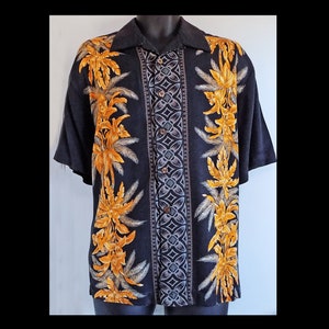 May include: A black short-sleeved button-down shirt with a tropical print featuring yellow palm trees and a geometric pattern.