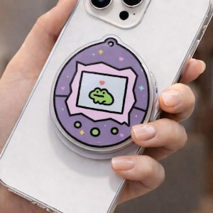 May include: A white ceramic mug with a black handle and the text "But First, Coffee" in a bold, black font. The mug is set against a blurred background, suggesting a cozy setting.