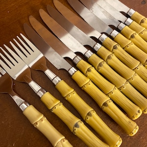 May include: A set of ten yellow bamboo handled stainless steel dinner knives and one matching fork.