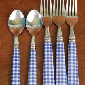 May include: Set of five silver utensils with blue and white checkered handles. The set includes two spoons and three forks.