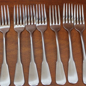 May include: Eight silver forks with a polished finish. The forks have a traditional design with a rounded handle and four tines.