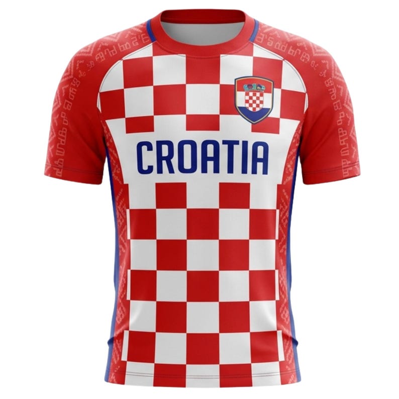 May include: Red and white checkered Croatia soccer jersey. The jersey features the word "CROATIA" in blue block letters across the chest, with the Croatian coat of arms on the upper chest. The sleeves have a red background with white patterns.