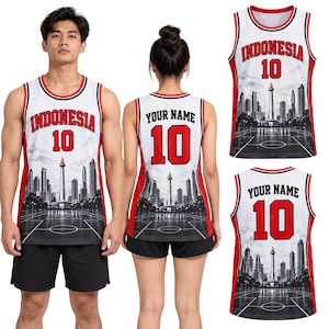 Puede incluir: Una camiseta de baloncesto blanca con ribetes rojos y negros, con el texto INDONESIA y el número 10 en la parte delantera, y YOUR NAME con el número 10 en la parte trasera. El diseño incluye un gráfico de un horizonte urbano y una cancha.