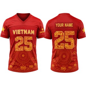 Peut inclure: Un maillot rouge à col en V avec le texte VIETNAM et le numéro 25 en doré sur le devant et le dos. Le design inclut des étoiles dorées sur les manches, un motif circulaire et des fleurs de lotus. Le dos présente un espace pour un nom.