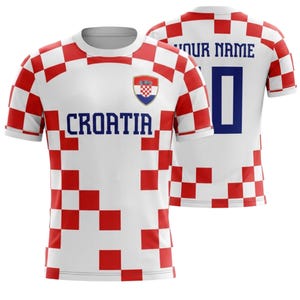 Op de afbeelding: Wit en rood geblokt Kroati&euml; voetbalshirt met het woord "CROATIA" over de borst. Het shirt heeft een Kroatisch wapen en het nummer "0" op de rug. Boven het nummer staat "YOUR NAME".