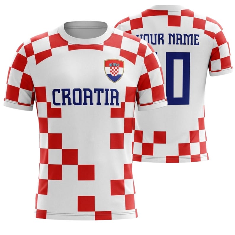 Op de afbeelding: Wit en rood geblokt Kroati&euml; voetbalshirt met het woord "CROATIA" over de borst. Het shirt heeft een Kroatisch wapen en het nummer "0" op de rug. Boven het nummer staat "YOUR NAME".