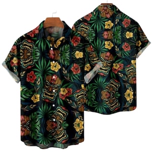 May include: Short-sleeved button-down shirt with a tropical design. The shirt features a repeating pattern of tiki masks, red and yellow flowers, and green foliage on a black background. The shirt is displayed on a wooden hanger.