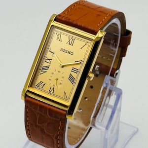 Rare Vintage Seiko Slim gold rectangular Seiko wristwatch with a brown leather strap, Roman numerals