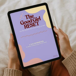 May include: A digital tablet displaying the title "The Good Girl RESET" in maroon lettering on a lavender background. The text "For the woman who's dove living on mute" is also visible. A stylus rests on the side.