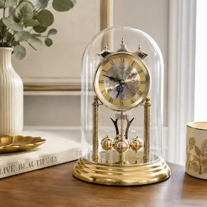 Orologio da tavolo vintage al quarzo Heinzler, Germania Ovest, con cupola in vetro e pendolo rotante.
