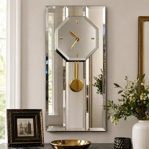 May include: A rectangular wall clock featuring a mirrored surface with a central octagonal clock face. The clock has gold-colored hands and a gold-colored pendulum. The mirrored frame is composed of vertical panels, reflecting the surrounding room.