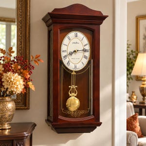 May include: A dark wood wall clock with a rectangular frame, a pediment top, and a glass door. The clock face is oval with black Roman numerals and the Seth Thomas logo. A gold-toned lyre pendulum hangs behind the glass, which features gold detailing.