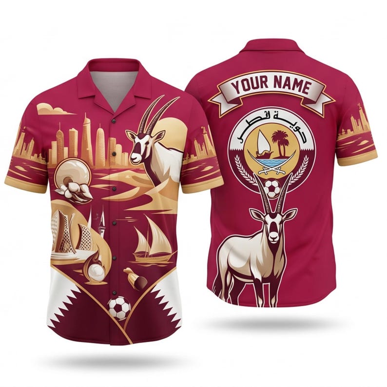 May include: A maroon button-up shirt with a design featuring a skyline, desert landscape, and an oryx. The back of the shirt has a Qatar emblem and space for a name. The shirt has short sleeves and a collar.