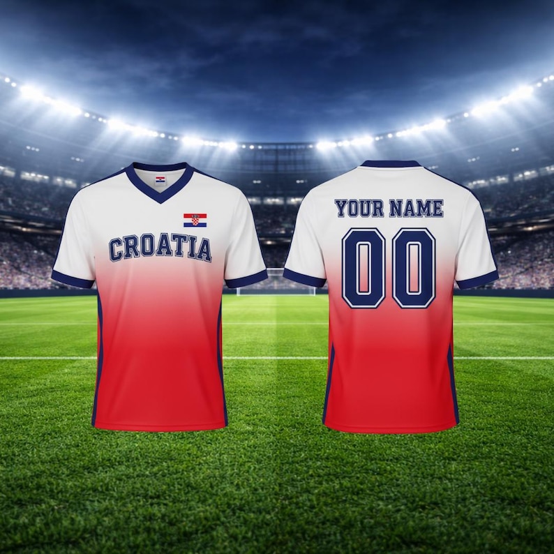 May include: A Croatia football shirt in white, red, and blue. The front displays "CROATIA" and the Croatian flag. The back has "YOUR NAME" above the number "00". The shirt has a V-neck and blue trim.
