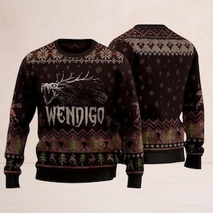 Puede incluir: Un suéter marrón oscuro con un gráfico de una criatura gruñona y la palabra "WENDIGO" en blanco. El suéter presenta un patrón repetido de árboles, ciervos y copos de nieve en tonos de verde, rosa y marrón. El suéter tiene cuello redondo y mangas largas.