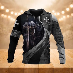 Op de afbeelding: Zwarte hoodie met een gedetailleerde afbeelding van een ridder in harnas die met een zwaard knielt. Het ontwerp bevat de woorden "TEMPLAR" en "KNIGHT TEMPLAR" met een kruisembleem. De mouwen hebben een maliënkolderpatroon.