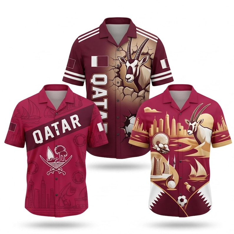 May include: Three maroon short-sleeve shirts with Qatar-themed designs. One shirt features the word "QATAR" and a graphic. Another has an oryx graphic. The third shirt has a skyline and oryx graphic. Each shirt has a collar and button-up front.