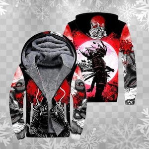 Puede incluir: Una sudadera con capucha negra con cremallera y un diseño de guerrero samurái rojo y blanco. La sudadera con capucha presenta un gráfico a todo color de un samurái con un fondo de luna roja y un forro polar gris.