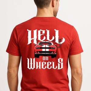 May include: Red t-shirt with the text "HELL ON WHEELS" in white gothic lettering. A red car with white racing stripes is centered above the text. The words "PRINTED ON BACK" are at the top.