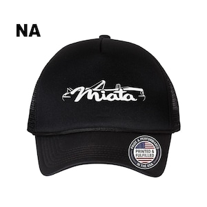 May include: A black trucker hat featuring a white graphic of a convertible car and the text Miata. The front panel displays the word NA in the upper left corner. A circular sticker on the brim reads Pride & Performance Printed & Fulfilled in the USA.