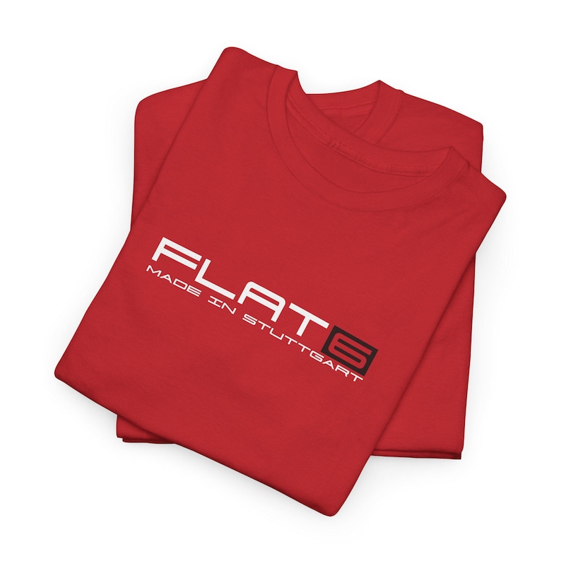 May include: Two folded red t-shirts. The top shirt has the word "FLAT6" in white, with "MADE IN STUTTGART" below it. The "6" is in a black box. The shirts are on a white background.