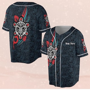 Puede incluir: Camiseta de béisbol azul oscuro con cuello y ribetes blancos. La camiseta presenta un diseño de tortuga tribal en blanco, rojo y verde azulado. La camiseta tiene el texto "Your Name" en la parte delantera.