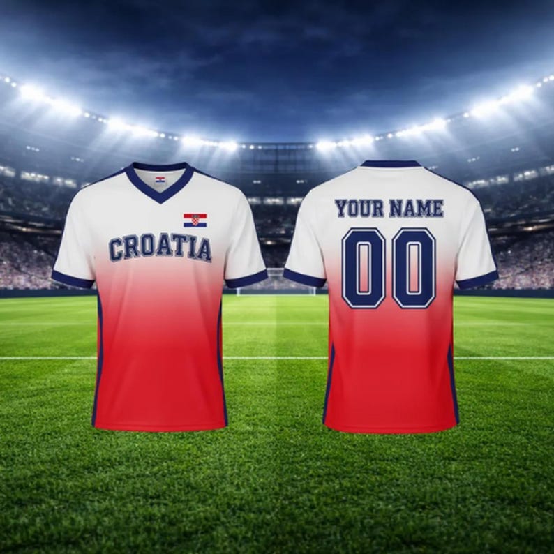 May include: White and red Croatia soccer jersey with the word "CROATIA" and the Croatian flag on the front. The back of the jersey has the number "00" and the text "YOUR NAME". The jersey has a V-neck and blue trim.