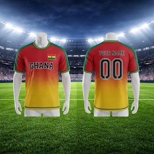 May include: A red, yellow, and green football shirt with "GHANA" and the Ghana flag on the front. The back of the shirt has the number "00" and the words "YOUR NAME". The shirt is displayed on a mannequin.