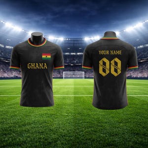 May include: Black football shirt with the word "Ghana" and the Ghana flag on the front. The back of the shirt has the number "00" and the words "YOUR NAME". The shirt has green, yellow, and red trim.